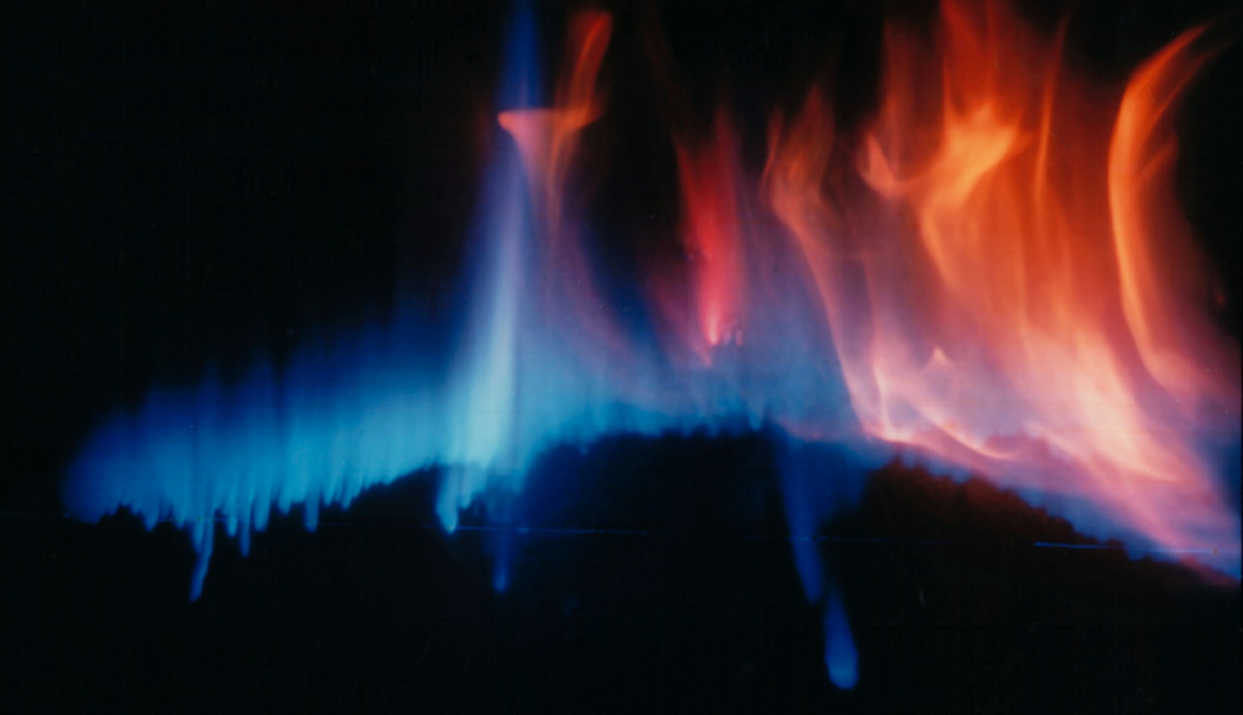 Vibrant abstract flames in shades of blue and orange on a dark background.